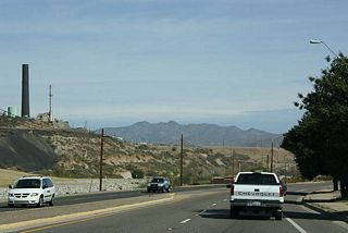 US 60 passes under the stack of the Miami copper smelter.