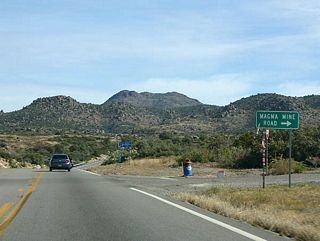 US 60 meets Magma Mine Road here. US 60 passes the Magma Copper Mine, which closed in 1987. There are talks about reopening the mine, but the plans are controversial as they would require loss of some recreational areas, such as Oak Flat.