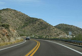 US 60 snakes alongside Queen Creek Canyon. A passing 
lane is just ahead, one that has been added after original 
construction.