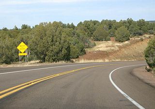 US 60 travels through a number of roadcuts ahead, as warned by this sign (advising to watch for rocks).