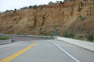 After crossing the new bridge, US 60 turns to follow the base of a small (relatively speaking) cliff. The old gas station and mini-mart located here is now closed.