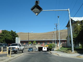 Orange Street lowers into a subway below five Montana Rail Link railroad tracks, two warehouses, and adjacent Railroad and 1st Streets. The underpass has a clearance of 13 feet 8 inches for U.S. 93 Business.1